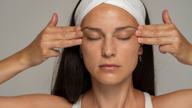 a young woman massaging her face